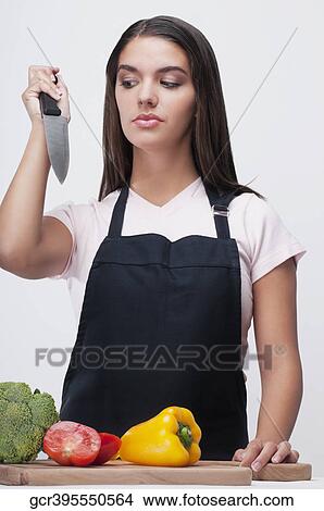 Woman attacking vegetables with a kitchen knife and thinking View Large Photo Image Picture - Woman attacking vegetables with a kitchen knife and thinking. Fotosearch