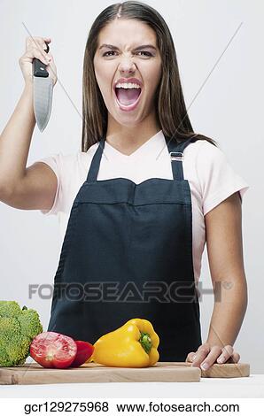Woman attacking vegetables with a kitchen knife View Large Photo Image Stock Photo - Woman attacking vegetables with a kitchen knife. Fotosearch