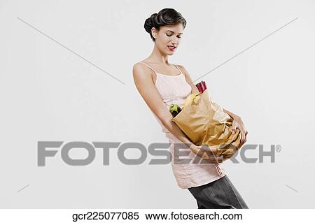 Woman carrying a bag of vegetables View Large Photo Image Stock Photography - Woman carrying a bag of vegetables. Fotosearch