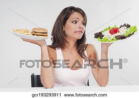 Woman choosing between a hamburger plate and a salad plate View Large Photo Image Stock Image - Woman choosing between a hamburger plate and a salad plate. Fotosearch