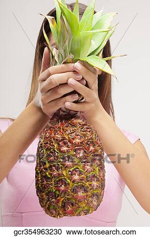 Woman covering her face with a pineapple View Large Photo Image Stock Image - Woman covering her face with a pineapple. Fotosearch