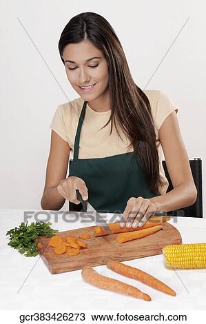 Stock Image - Woman cutting vegetables. Fotosearch