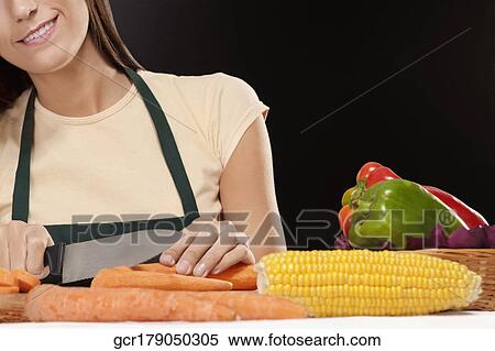 Stock Photography - Woman cutting vegetables. Fotosearch