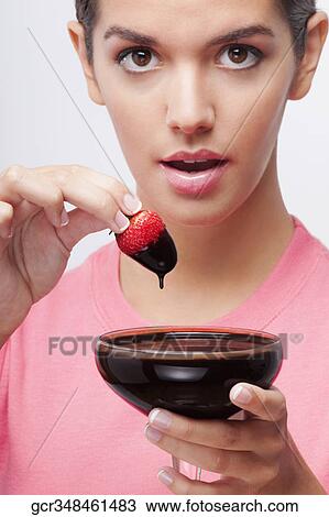 Woman dipping a strawberry in chocolate sauce View Large Photo Image Stock Image - Woman dipping a strawberry in chocolate sauce. Fotosearch