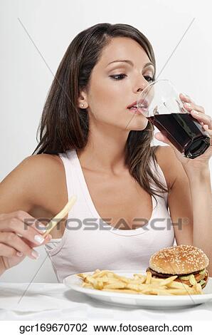 Woman drinking a cola with hamburger and fries View Large Photo Image Stock Image - Woman drinking a cola with hamburger and fries. Fotosearch