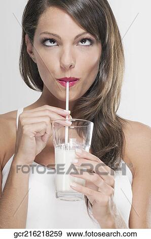 Woman drinking milk with a straw View Large Photo Image Stock Photo - Woman drinking milk with a straw. Fotosearch