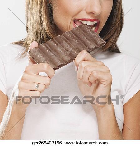 Woman eating a bar of chocolate View Large Photo Image Stock Photograph - Woman eating a bar of chocolate. Fotosearch