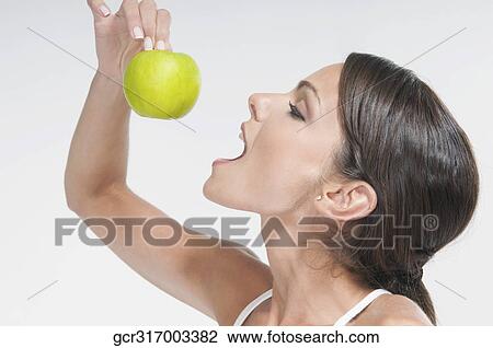 Woman eating a green apple View Large Photo Image Stock Image - Woman eating a green apple. Fotosearch