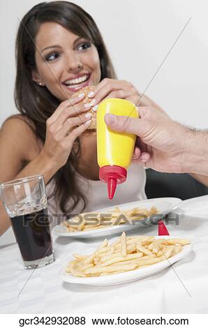 Woman eating a hamburger View Large Photo Image Stock Photo - Woman eating a hamburger. Fotosearch