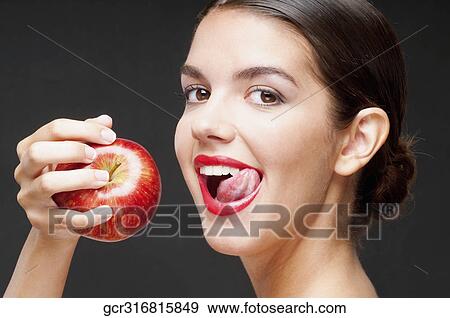 Woman eating a red apple and licking lips View Large Photo Image Stock Photo - Woman eating a red apple and licking lips. Fotosearch