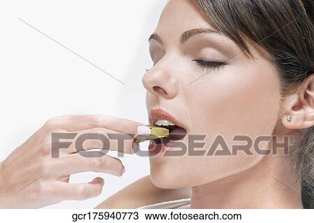 Woman eating a slice of kiwi fruit View Large Photo Image Stock Image - Woman eating a slice of kiwi fruit. Fotosearch