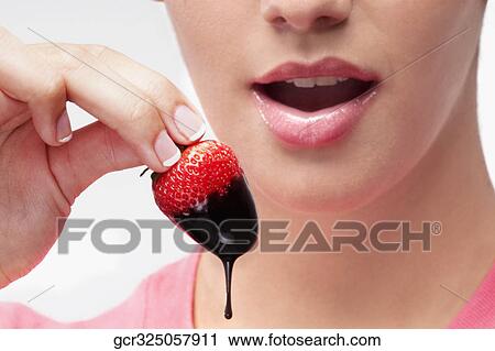 Woman eating a strawberry dipped in chocolate sauce View Large Photo Image Stock Image - Woman eating a strawberry dipped in chocolate sauce. Fotosearch