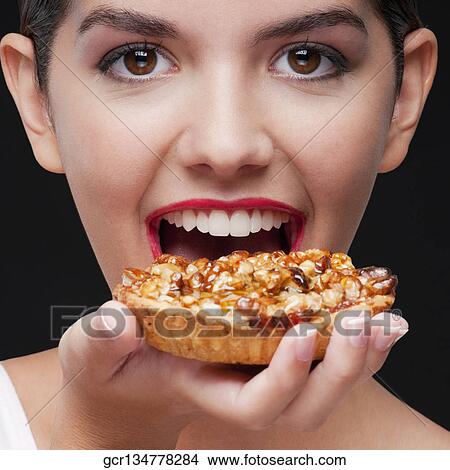 Woman eating a tart and smiling View Large Photo Image Picture - Woman eating a tart and smiling. Fotosearch
