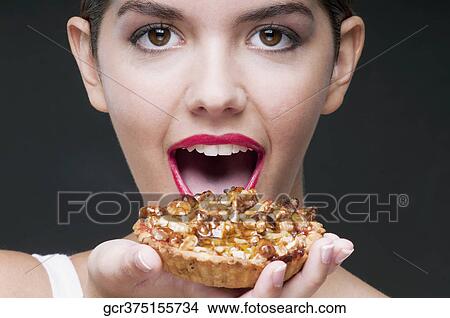 Woman eating a tart and smiling View Large Photo Image Picture - Woman eating a tart and smiling. Fotosearch