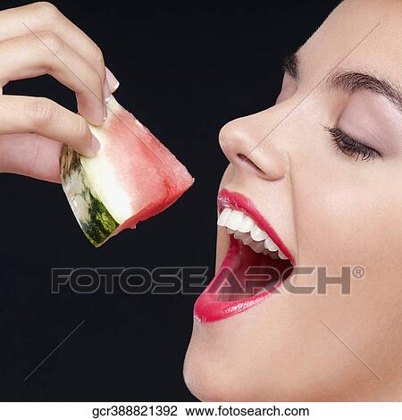 Woman eating a watermelon slice and smiling View Large Photo Image Stock Image - Woman eating a watermelon slice and smiling. Fotosearch