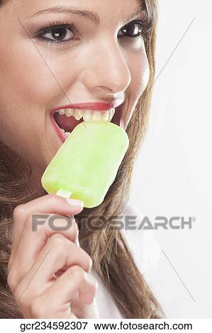 Woman eating an ice lolly View Large Photo Image Stock Photo - Woman eating an ice lolly. Fotosearch