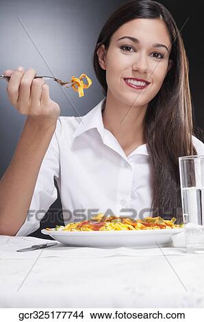 Woman eating pasta and smiling View Large Photo Image Picture - Woman eating pasta and smiling. Fotosearch