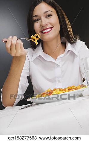 Woman eating pasta and smiling View Large Photo Image Stock Image - Woman eating pasta and smiling. Fotosearch