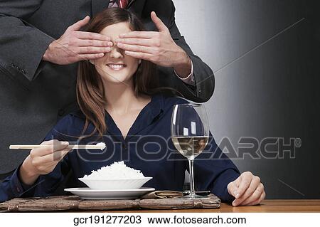Woman eating rice and a man covering her eyes View Large Photo Image Stock Image - Woman eating rice and a man covering her eyes. Fotosearch