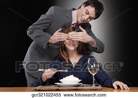 Woman eating rice and a man covering her eyes View Large Photo Image Stock Photography - Woman eating rice and a man covering her eyes. Fotosearch