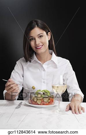 Picture - Woman eating salad and smiling. Fotosearch