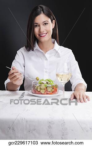 Stock Image - Woman eating salad and smiling. Fotosearch