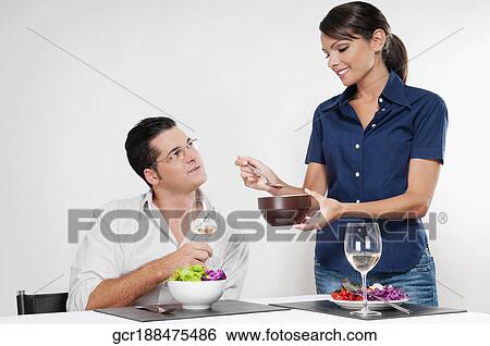 Woman feeding her husband from a bowl View Large Photo Image Stock Photograph - Woman feeding her husband from a bowl. Fotosearch