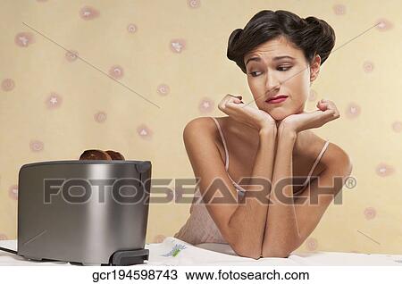 Woman frowning at burnt toast View Large Photo Image Stock Image - Woman frowning at burnt toast. Fotosearch