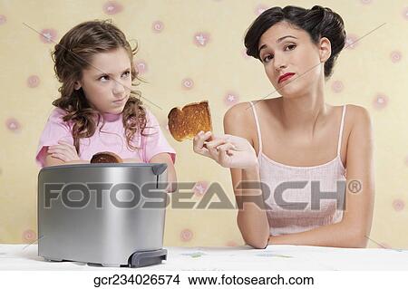 Woman giving her daughter a burnt toast View Large Photo Image Picture - Woman giving her daughter a burnt toast. Fotosearch