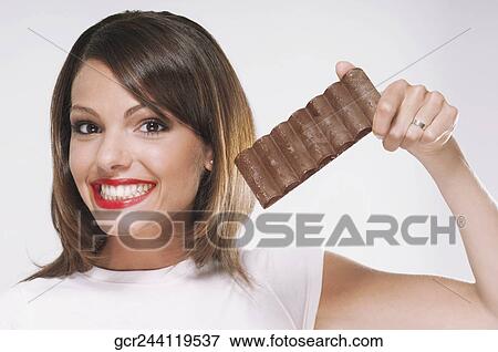 Stock Photo - Woman holding a bar of chocolate. Fotosearch