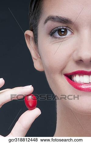 Woman holding a cherry tomato and smiling View Large Photo Image Stock Photo - Woman holding a cherry tomato and smiling. Fotosearch