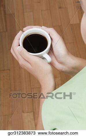 Woman holding a cup of black coffee View Large Photo Image Stock Image - Woman holding a cup of black coffee. Fotosearch