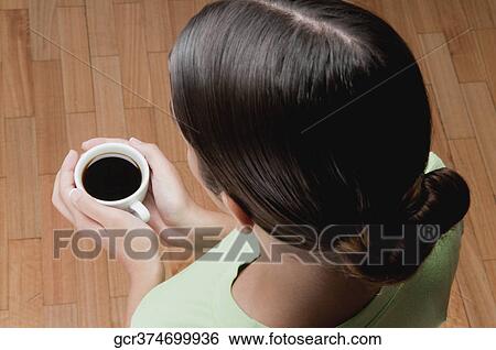 Woman holding a cup of black coffee View Large Photo Image Stock Photograph - Woman holding a cup of black coffee. Fotosearch