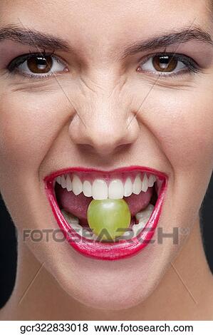 Woman holding a green grape between her teeth View Large Photo Image Stock Photo - Woman holding a green grape between her teeth. Fotosearch