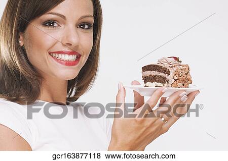 Woman holding a pastry on a plate View Large Photo Image Stock Photo - Woman holding a pastry on a plate . Fotosearch