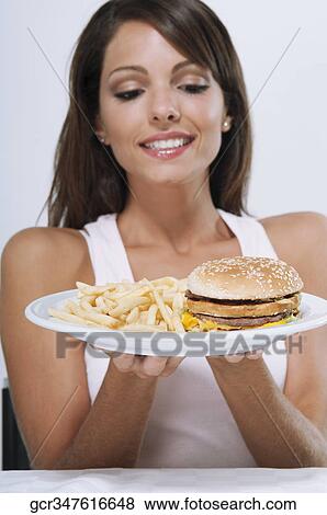 Woman holding a plate of hamburger and fries View Large Photo Image Stock Photo - Woman holding a plate of hamburger and fries. Fotosearch