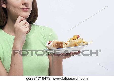 Woman holding a plate of hot dog and potato chips View Large Photo Image Stock Image - Woman holding a plate of hot dog and potato chips. Fotosearch