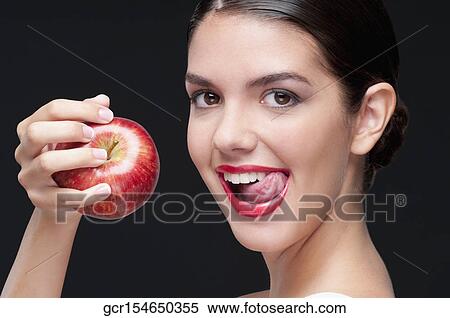 Woman holding a red apple and licking lips View Large Photo Image Stock Photography - Woman holding a red apple and licking lips. Fotosearch