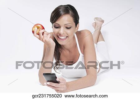 Woman holding a red apple and using a mobile phone View Large Photo Image Stock Image - Woman holding a red apple and using a mobile phone. Fotosearch