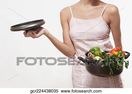 Woman holding a saucepan of fresh vegetables View Large Photo Image Stock Photography - Woman holding a saucepan of fresh vegetables. Fotosearch