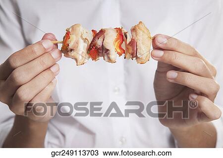 Woman holding a shish kebab View Large Photo Image Stock Image - Woman holding a shish kebab. Fotosearch