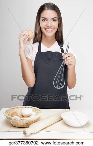 Woman holding an egg and wire whisk View Large Photo Image Stock Image - Woman holding an egg and wire whisk. Fotosearch