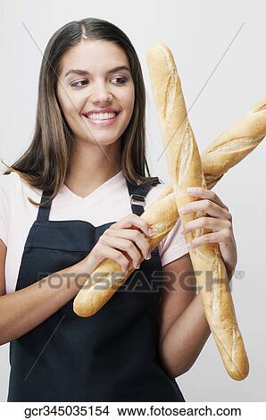 Picture - Woman holding baguettes and smiling. Fotosearch
