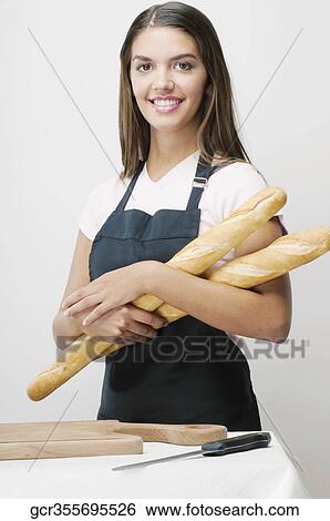 Woman holding baguettes and smiling View Large Photo Image Stock Photograph - Woman holding baguettes and smiling. Fotosearch