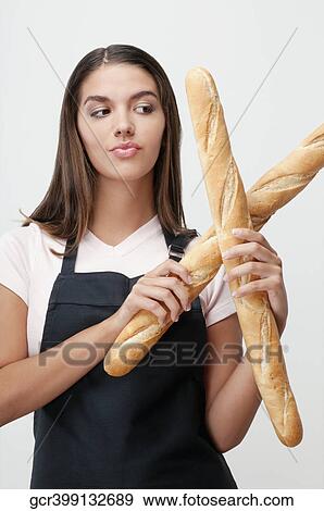 Woman holding baguettes and thinking View Large Photo Image Stock Photo - Woman holding baguettes and thinking. Fotosearch