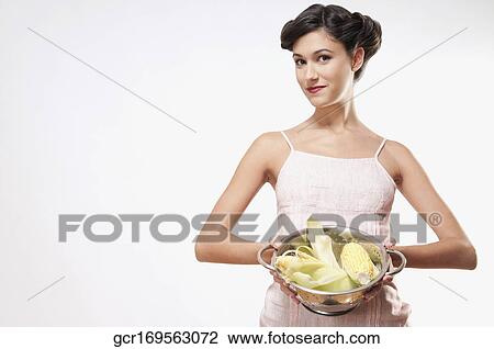 Woman holding corncobs in a colander View Large Photo Image Stock Image - Woman holding corncobs in a colander. Fotosearch