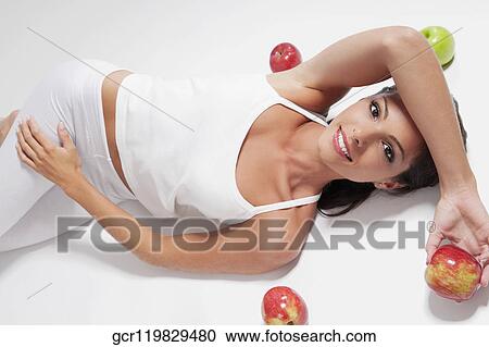 Woman lying with red and green apples View Large Photo Image Stock Image - Woman lying with red and green apples. Fotosearch
