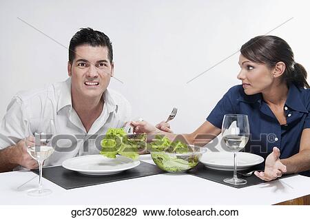 Stock Photo - Woman serving salad to her husband. Fotosearch