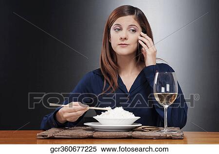 Woman talking on a mobile phone and eating rice View Large Photo Image Stock Photography - Woman talking on a mobile phone and eating rice. Fotosearch