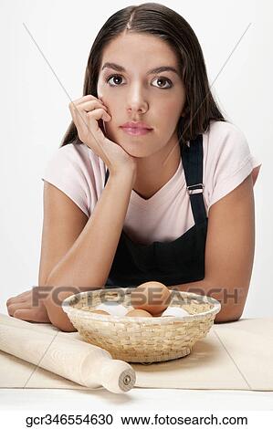 Woman thinking with a basket of eggs and a rolling pin View Large Photo Image Stock Image - Woman thinking with a basket of eggs and a rolling pin. Fotosearch
